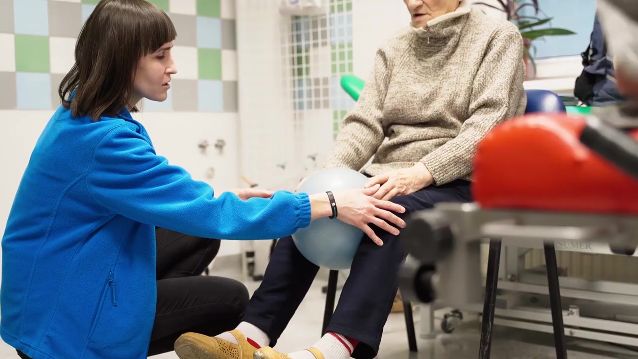 Ćwiczenia z piłką rehabilitacyjną przy wsparciu prowadzącego.
