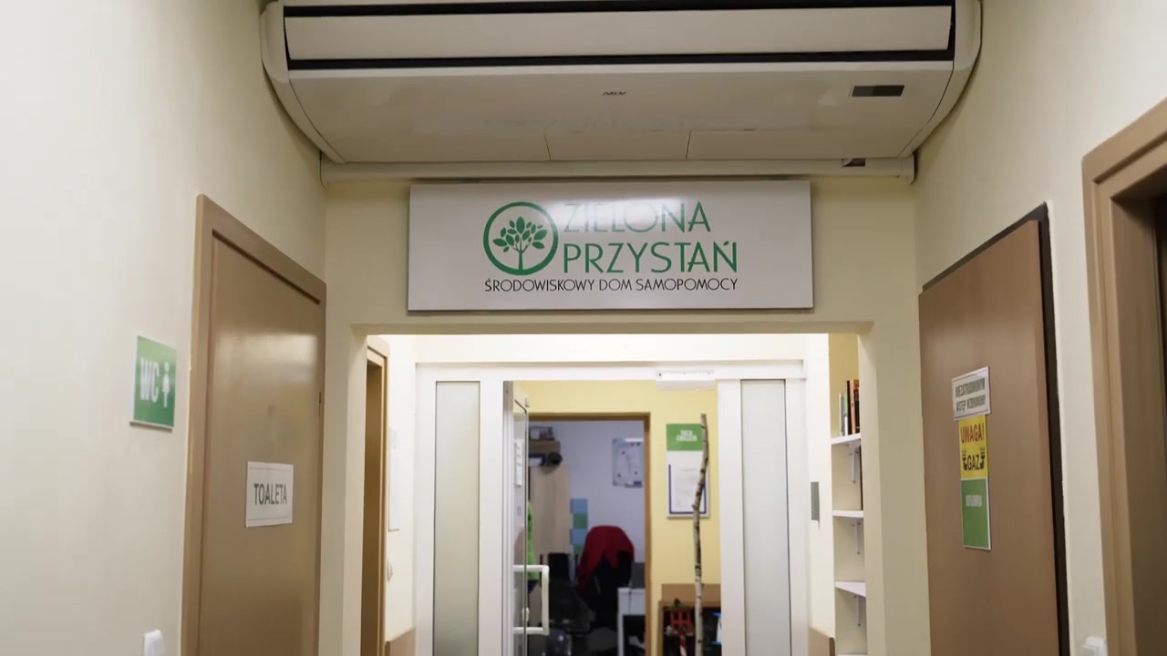 Wejście do pomieszczeń Zielonej Przystani z tablicą Fundacji nad drzwiami.